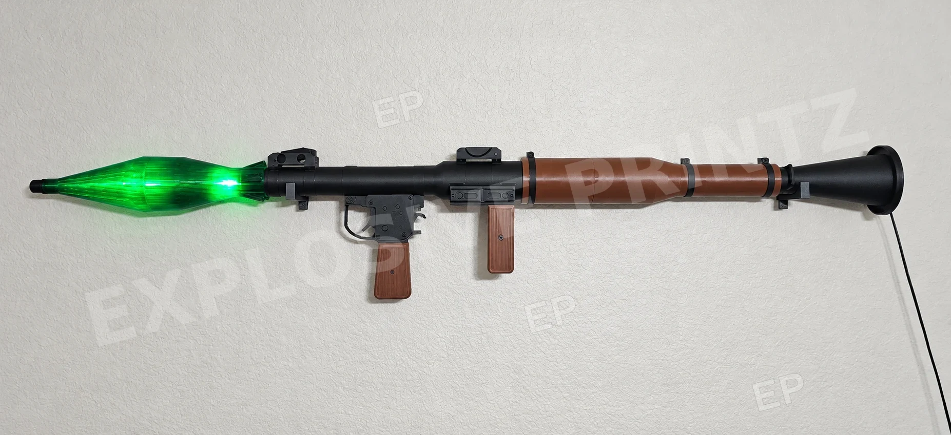 The Nightstrike in room lighting, with black body, brown grips and illuminated green rocket